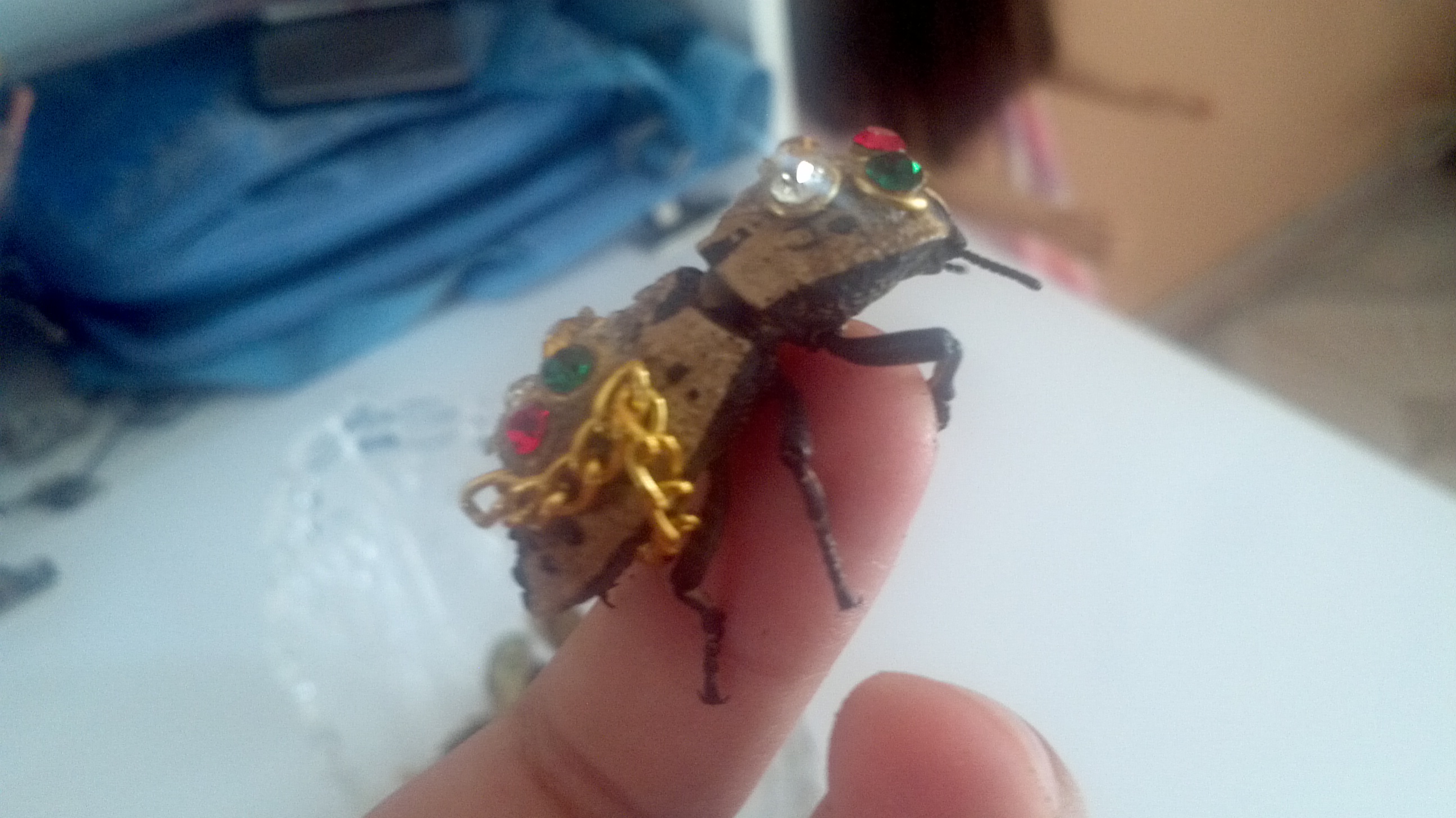 A living Maquech beetle decorated with colourful ornaments and attached to a chain